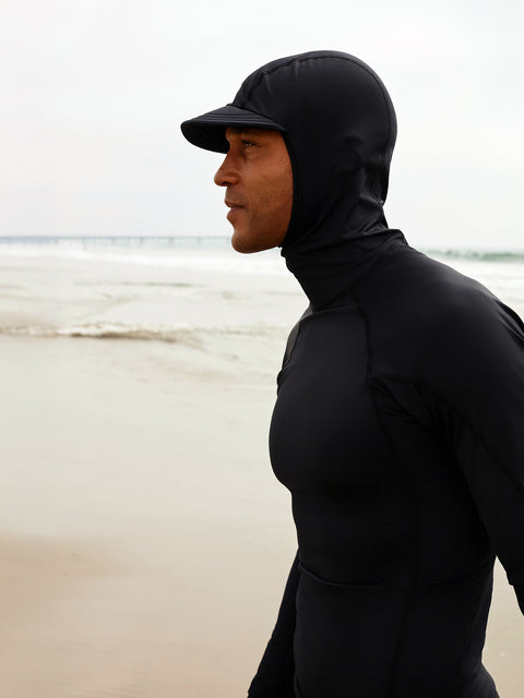A man wearing the best sun protection for surfers on the beach