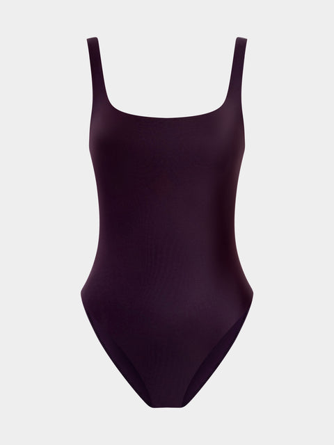 Purple swimsuit with thin straps on a light gray background
